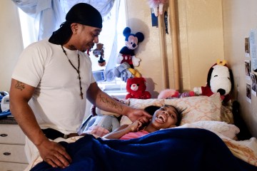 image: David Stephens plays with his daughter, Tatiana, in his apartment in the Redfern Houses in Far Rockaway, Queens, New York on Jan. 30, 2012. David sent Tatiania, who suffered a brain infection that left her paralyzed, to live with his in-laws during the two weeks with no electricity after Sandy.