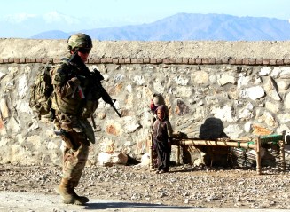 Children look at a female U.S. soldier on patrol in Pachir wa Agam in Nangarhar