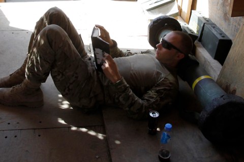 A soldier from 3rd Platoon, 2-27 Infantry uses a Javelin rocket as a pillow while reading a book in Outpost Bari Alai in Ghaziabad district in Kunar, Afghanistan.   