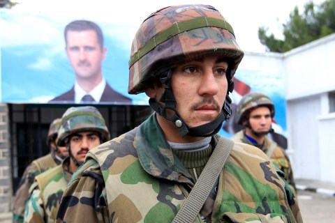 Syrian soldiers attend the funeral of their comrades at a military hospital in Homs