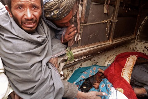 A mourner cries over the bodies of Afgha