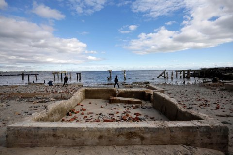 A man walks past the remains of a building near a damaged section of boardwalk in the wake of superstorm Sandy, Wednesday, Oct. 31, 2012, in Atlantic City, N.J. 