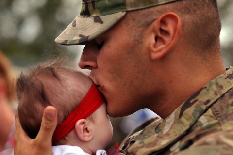 image: U.S. Army Spc. Cory Allen kisses his daughter Lacey Allen during a welcome home ceremony at Fort Stewart, Ga., for soldiers from the Army's 1st Battalion, 30th Infantry Regiment, Oct. 10, 2012.