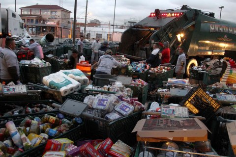 image: Men dispose of shopping carts full of food damaged by Hurricane Sandy at the Fairway supermarket in the Red Hook section of Brooklyn, N.Y., on Wednesday, Oct. 31, 2012.