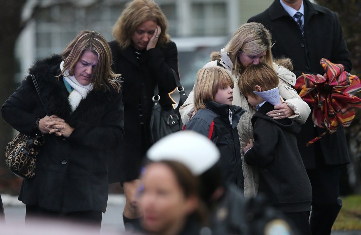image: A woman comforts a boy as mourners depart Honan Funeral Home after the funeral for 6-year-old Jack Pinto in Newtown, Conn., Dec. 17, 2012.