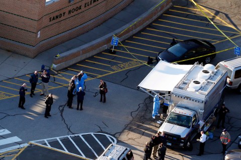 Officials work at the scene of the shooting at Sandy Hook Elementary in Newtown, Conn., on Friday, Dec. 14.