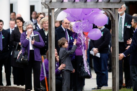 Jake Hockley releases balloons as people look on during the funeral service for his brother, Sandy Hook Elementary School shooting victim Dylan Hockley, at Walnut Community Church in Bethel, Connecticut
