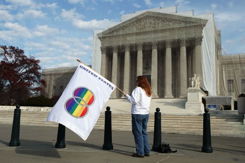 image: Same-sex marriage proponent Kat McGuckin of Oaklyn, N.J., holds a gay pride flag while standing in front of the Supreme Court in Washington, Nov. 30, 2012.