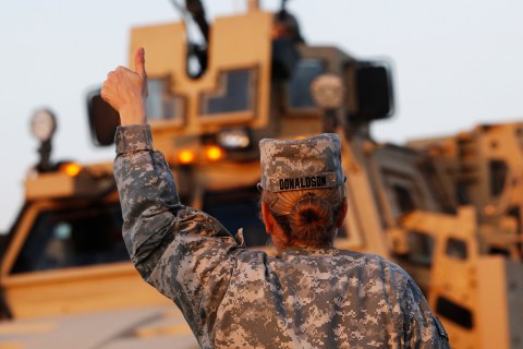U.S. Army convoys are given the thumbs up from a fellow soldier after crossing into Kuwait during the last convoy out of Iraq