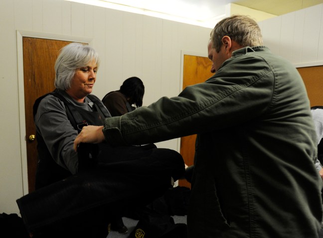 image: Charlene McMurry, an elementary school principal in Alabama's Jefferson County, gets help from a sheriff's deputy as she puts on protective clothing before taking part in an active school-shooter simulation in Birmingham on Jan. 2, 2013.