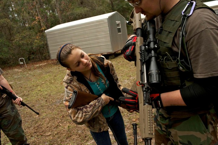 A member of the North Florida Survival Group shows a young girl how to operate an SKS rifle during a field training exercise in Old Town