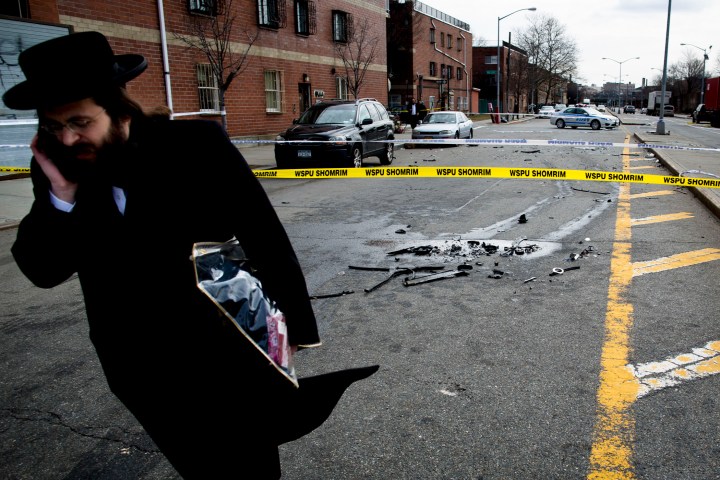 A man walks past debris from a fatal accident that claimed the lives of two expectant parents on their way to the hospital early on March 3, 2013, in the Brooklyn borough of New York.