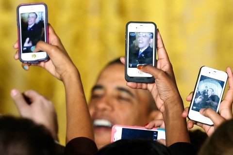 Attendees photograph U.S. President Obama with their phones at a Women's History Month reception in Washington