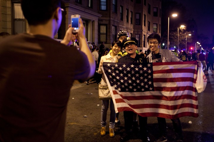 A few of the estimated 200 people who poured onto Hemingway Street in the Fenway neighborhood to celebrate after the announcement earlier of the capture of the second  Boston Martathon bombing suspect celebrate on April 19, 2013 in Boston, Mas.