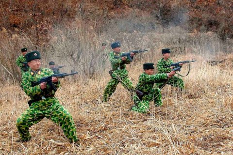 North Korean soldiers with weapons attend military training in an undisclosed location