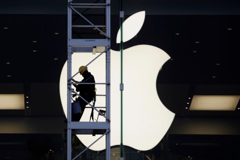 A worker climbs outside an Apple store in Hong Kong