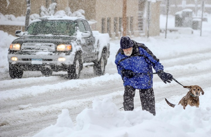 Mike Gregg trudges through the snow to walk his dog, Jake, in Austin, Minn., on morning, May 2, 2013. 