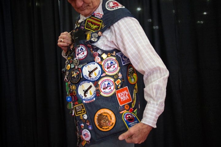 NRA lifetime member Lee Smith, 79, from Houston, shows off his vest covered in pins and patches to event attendees while taking part in the National Rifle Association's annual meeting in Houston, Texas