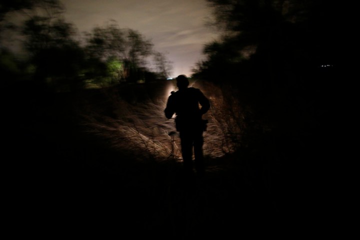 A U.S. Border Patrol agent searches for illegal immigrants who crossed the Rio Grande River in Mission, Texas