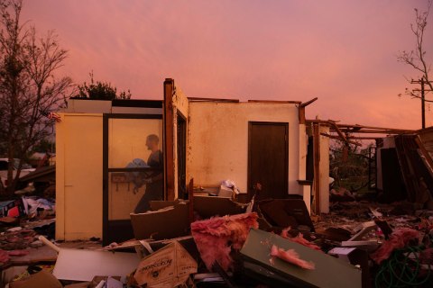 Jason Owen walks past an open door as he helps his mother to salvage items from her uncle's home after it was almost destroyed by a tornado in Moore, Oklahoma, May 23, 2013. 