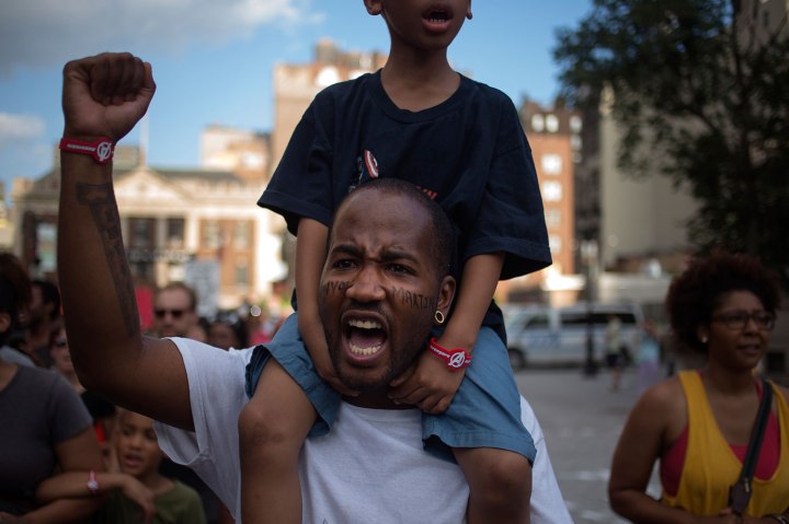 Terill Powell carries his five-year-old son Maurice Powell amidst hundreds of activists who are demanding justice for Trayvon Martin while marching to Times Square from New York's Union Square