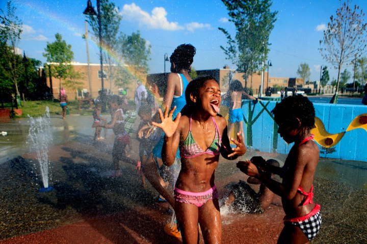 Emonee Hester, 9, cools off with her sister Alquida, 8, and others while at the Jess Allen Park's water sprinklers in Newark, N.J., on July 18, 2013.