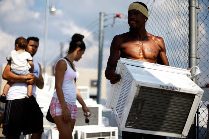 Salesman Lu Pichardo carries a customer's air conditioner at Appliances R Us in Philadelphia, on July 18, 2013.