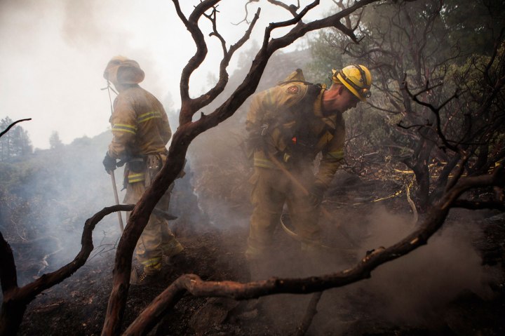 El Dorado Hills firefighter Ben Cowles, right, battles a hotspot while fighting the Rim Fire in Yosemite National Park, Calif., Aug. 24, 2013. 