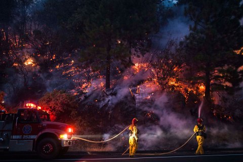 Firefighters work to prevent the Rim Fire from jumping Highway 120 near Buck Meadows, Calif., Aug. 24, 2013. A fast-moving wi