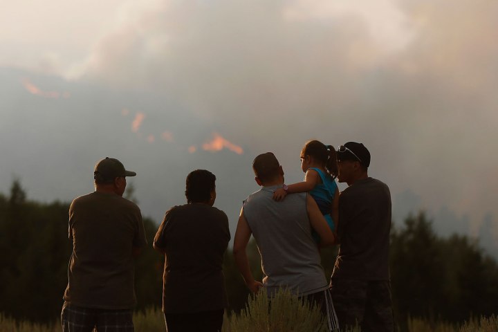 A family watches as the Beaver Creek wildfire rages outside Hailey