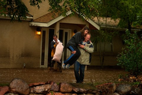 Kim Schuler carries his wife Cheryl from their home after salvaging what they in Boulder, Colo., September 12, 2013.