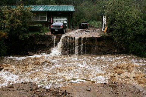 A home and car are stranded after a flash flood in Coal Creek destroyed the bridge near Golden, Colo., September 12, 2013.