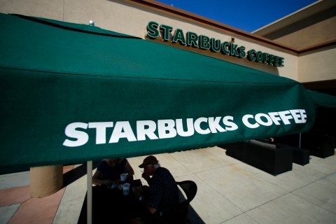 Customers enjoy their drinks outside a newly designed Starbucks coffee shop in Fountain Valley