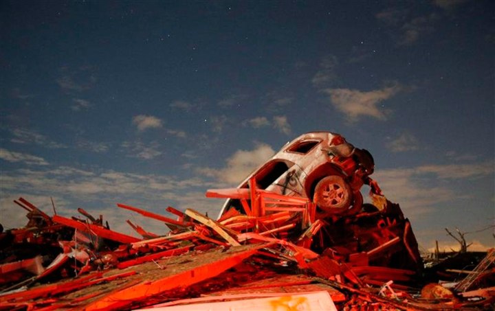 A vehicle sits on a pile of debris from the destruction caused by a tornado that touched down in Washington, Ill., on Nov. 17, 2013.