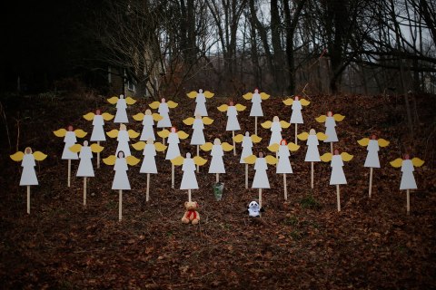 Twenty-seven wooden angel figures are seen placed in wooded area beside road near Sandy Hook Elementary School for victims of school shooting in Newtown, Connecticut