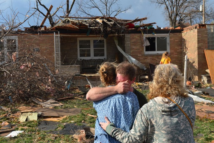 Ray Baughman embraces his family shortly after his home was destroyed by a tornado that left a path of devastation through the north end of Pekin, Ill. on Nov. 17, 2013. 