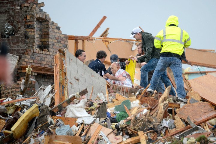 Rescuers pull an injured resident from a demolished house after a tornado destroyed parts of Washington, Ill. on Nov. 17, 2013. 