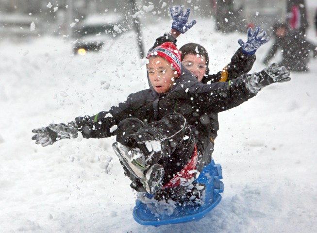 From left: Robert Guthrie, 7, and his buddy Eli Glasgow, 8, fly over a snow bump on a track they and their friends made along the sidewalk in Duluth's Central Hillside, on Dec. 3, 2013.