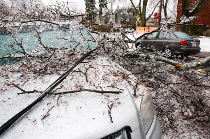 A downed powerline runs over a parked vehicle after ice covered tree branches came down after freezing rain in Toronto, on Dec. 22, 2013.