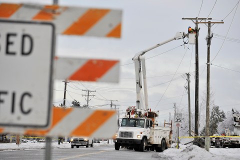 Crews work to restore power lines that were damaged along DeMille Road in Lapeer, Mich. on Dec. 23, 2013, after the ice storm over the weekend.
