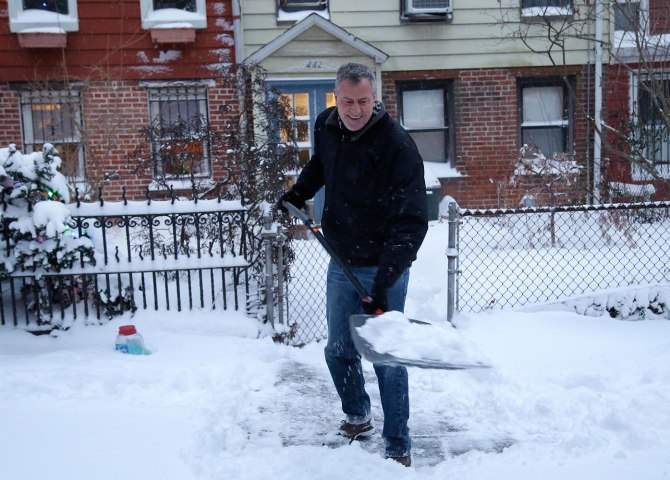 New York City Mayor Bill de Blasio shovels the sidewalk in front of his house in New York, Jan. 3, 2014.