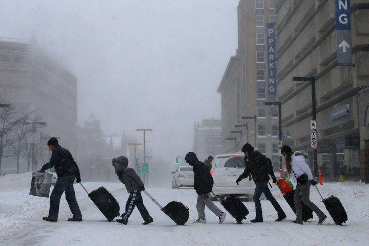 Travelers leave Back Bay train and subway station during winter nor'easter snow storm in Boston