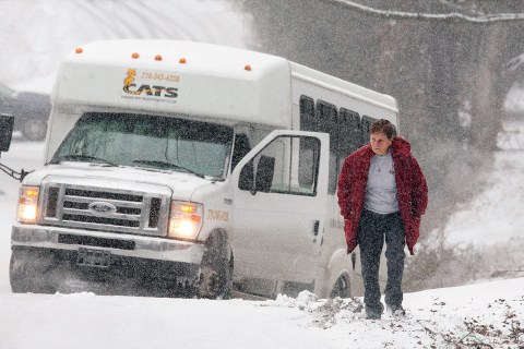 The driver of a Cherokee County Area Transportation System bus is sidelined in a ditch on Killian Road, Tuesday, Jan. 28, 2014 in Canton, Ga. 