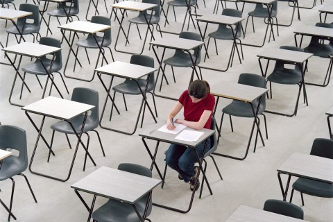 Young woman taking an exam at her desk.