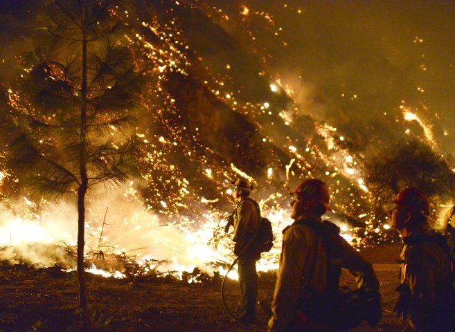 U.S. Forestry Service fire crews conduct a burnout operation as flames near homes in Azusa, Calif., January 16, 2014.