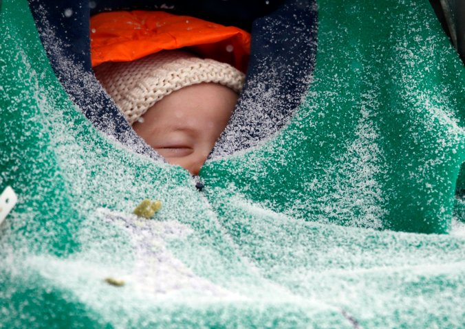 Two-month-old Jack Hsi takes a nap sheltered in his baby carrier while snow falls in Boston, Jan. 2, 2014.