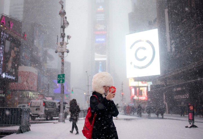 A female tourist from Japan takes a selfie during a snowstorm in Times Square, New York, January 21, 2014. 