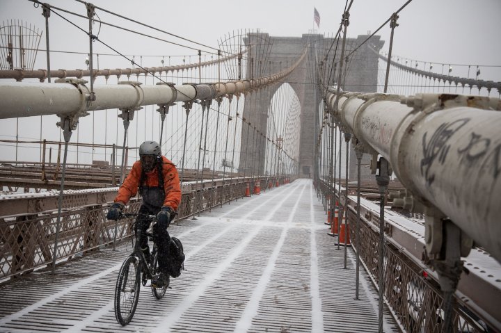A man rides his bike across the Brooklyn Bridge during a snowstorm that is moving through the Northeast on January 21, 2014 in New York City. 