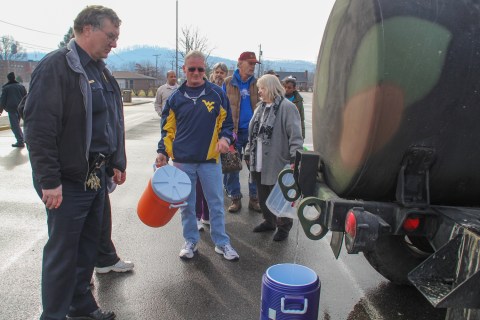 Residents line up for water at a water filling station at West Virginia State University, in Institute