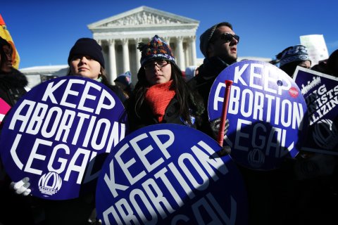 Pro-choice activists hold signs as marchers of the annual March for Life arrive in front of the U.S. Supreme Court Jan. 22, 2014 on Capitol Hill in Washington, D.C.